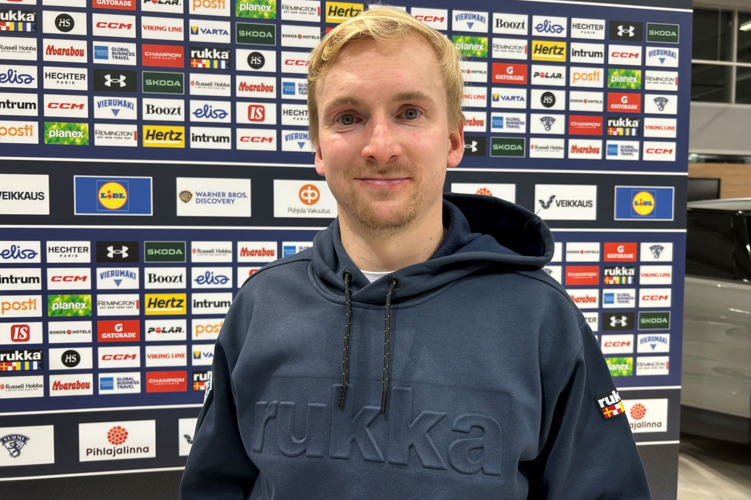 Mies seisoo mainosseinän edessä.