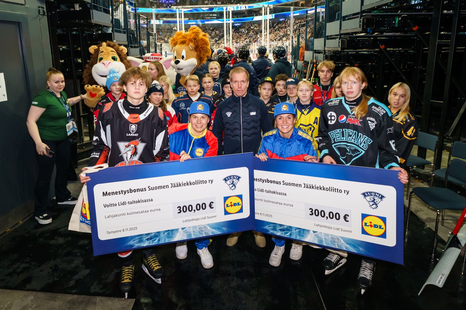 Jääkiekkoasuisia lapsia jäähallissa.