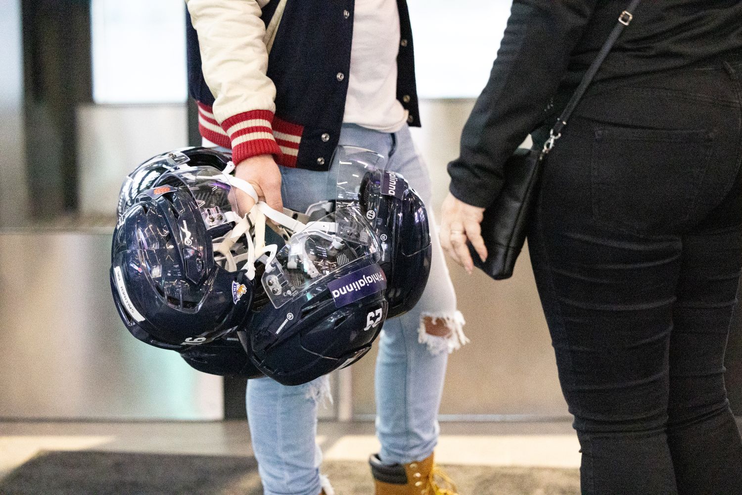 Jääkiekkokypäriä miehen kädessä.